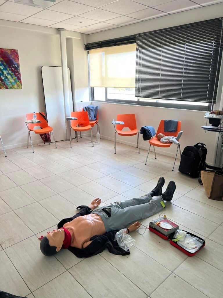 Formateur accompagnant un participant lors d'un exercice de secourisme