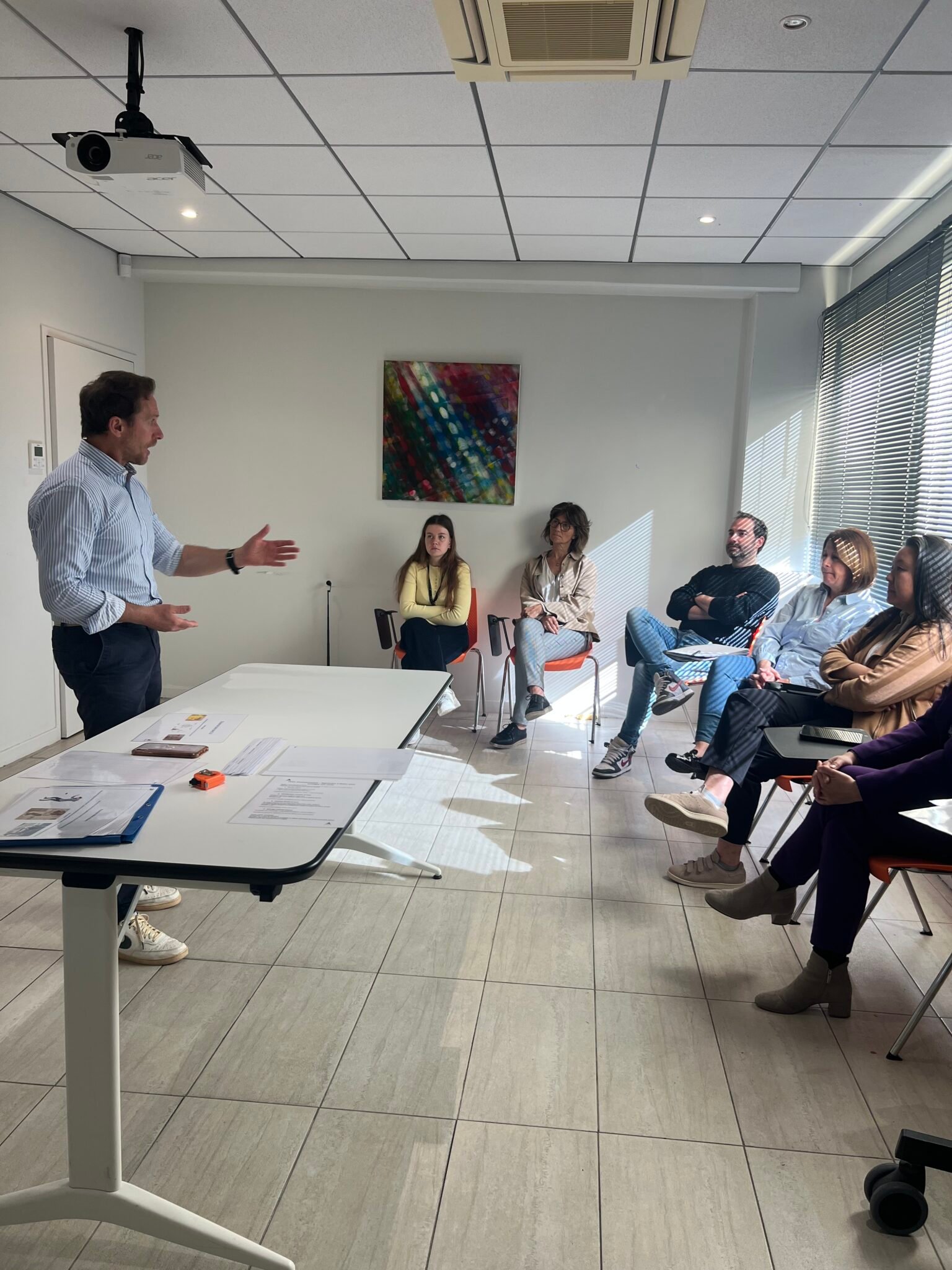 Formateur animant une session devant un groupe de participants en salle